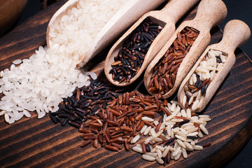 Different types of rice on a wooden background