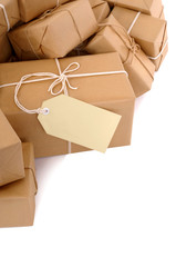 Untidy pile or heap of several lots brown paper wrapped parcel package or gift boxes one with blank label or gift tag isolated on white background photo