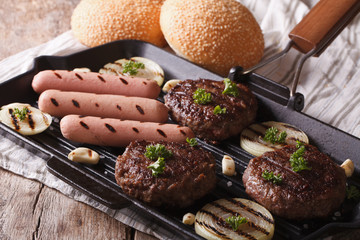 burgers and sausages with vegetables on a grill pan, horizontal