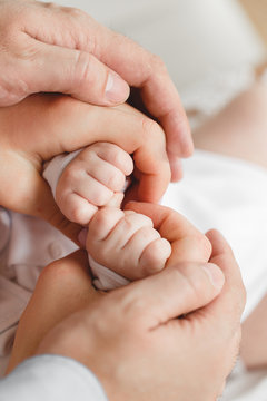 Newborn hands and the hands of parents.