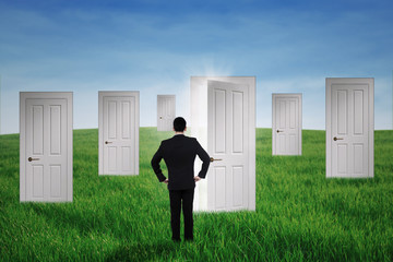 Fototapeta premium Businessman walking to opportunity doors