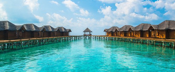 Fototapeta premium Over water bungalows with steps into amazing green lagoon