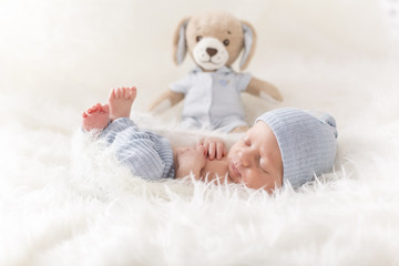 Newborn Baby mit süßem Outfit und Teddy