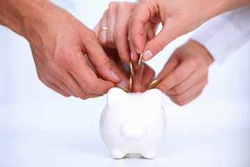Putting coin into the piggy bank