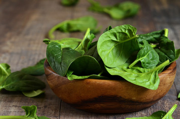 Spinach leaves in a wooden bowl.