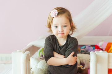 Interior portrait of a cute toddler girl in her room