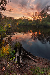 Beautiful autumn sunset at the river in the forest