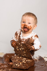 Kleines Baby mit Schokolade verschmiert