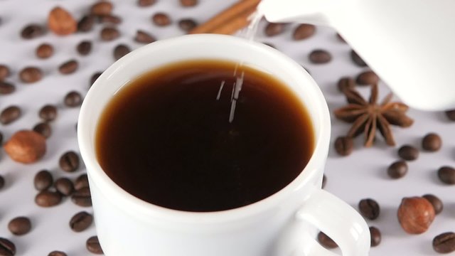 Pouring splashing coffee into a cup, slow motion