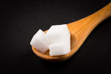 Fototapeta na wymiar White refined sugar in wooden spoon