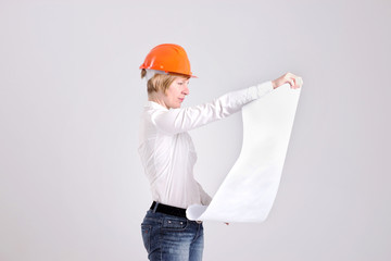 Archictress in Safety Helmet Looks to Architectural Plans
