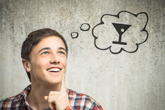 Junger Mann denkt an Cocktail