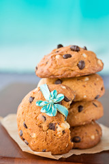 Stacked chocolate chip cookies with ribbon, on blue background