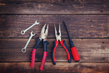 top view of worn work gloves and assorted work tools over wooden