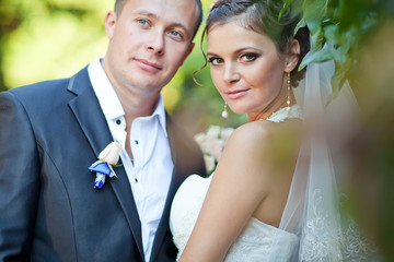 bride and groom are walking in green park