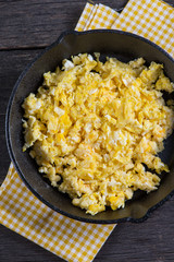 scrambled eggs in vintage frying iron pan, overhead view