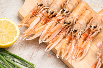 Scampi crudi sul tagliere di legno