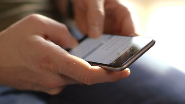 Young man texting on smartphone from home