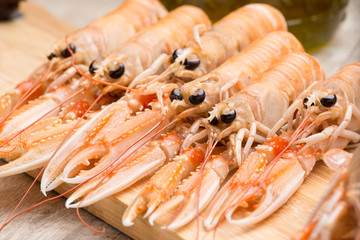 Scampi crudi sul tagliere di legno