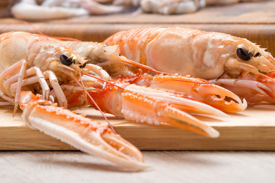 Scampi crudi sul tagliere di legno