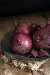 Moody natural light vintage retro style image of fresh red onion