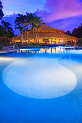 Luxury swiming pool in a tropical resort at sunset