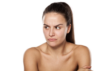 scowling dissatisfied young woman without makeup