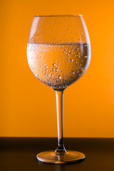 Glass of Water over orange background