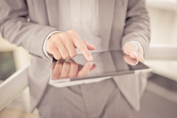 Businessman using electronic tablet pc. He is sitting on a stair