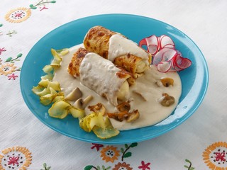 pancakes with cheese and potato filling under mushrooms sauce