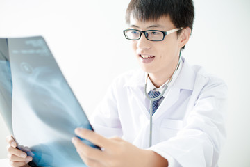 close up of male doctor holding x-ray or roentgen image