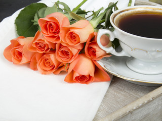 Fototapeta na wymiar cup of coffee and a bouquet of roses on a tray