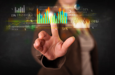 Young business woman touching colorful charts and diagrams