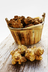 Fresh organic topinambur on wooden background, Jerusalem articho