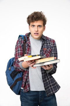 Surprised young man with books over gray background