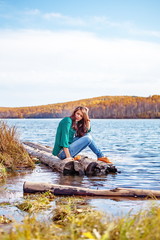 Young girl sitting on the river bank