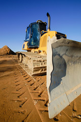 Baubranche - Baufahrzeug, Bulldozer auf einem Baugrundstück