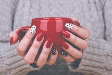 Woman with manicured nails holding a cup - obrazy, fototapety, plakaty