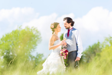 Hochzeitspaar feiert draußen Hochzeitstag mit Sekt