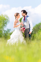 Hochzeitspaar feiert draußen Hochzeitstag mit Sekt