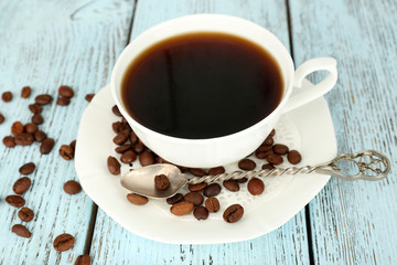 Cup of coffee with beans on color rustic wooden background
