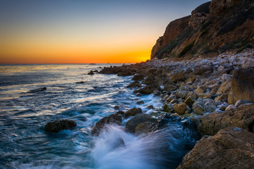 Waves crashing on rocks at Pelican Cove at sunset, in Rancho Pal