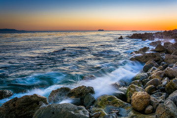 Fototapeta na wymiar Waves crashing on rocks at Pelican Cove at sunset, in Rancho Pal