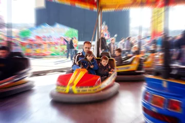 Deurstickers Father and his two sons,l having a ride in the bumper car at the © Tomsickova