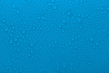 Naklejka na ściany i meble Water drops on glass on light background