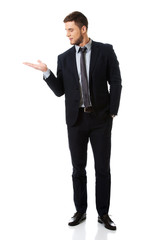 Handsome businessman holding copyspace on palm.