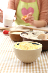 Young woman prepares dough on table close up