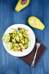 Salad with apple and avocado in bowl on table close up