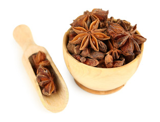 Star anise in wooden bowl, isolated on white