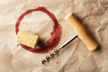 Wine stain, cork and corkscrew on crumpled paper background